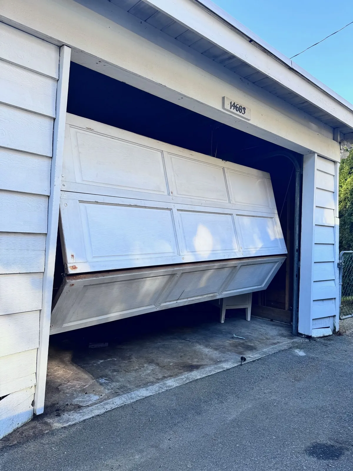 Old wooden garage door collapsed off its tracks at a Tsawwassen home